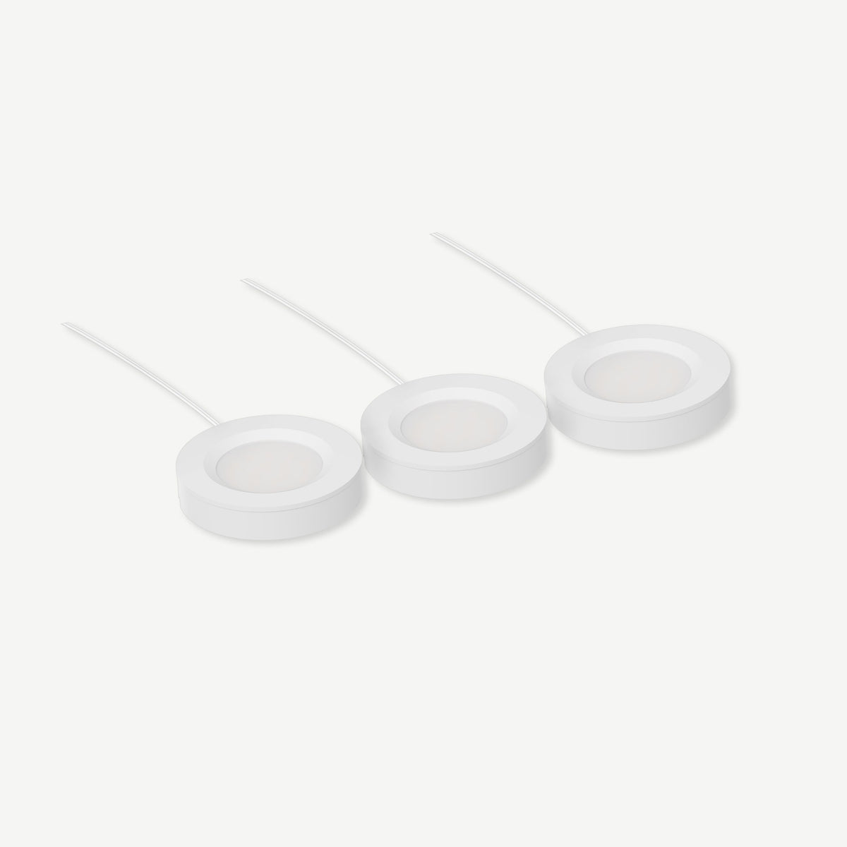 Three slim white INLIGHT LED puck lights with attached cables