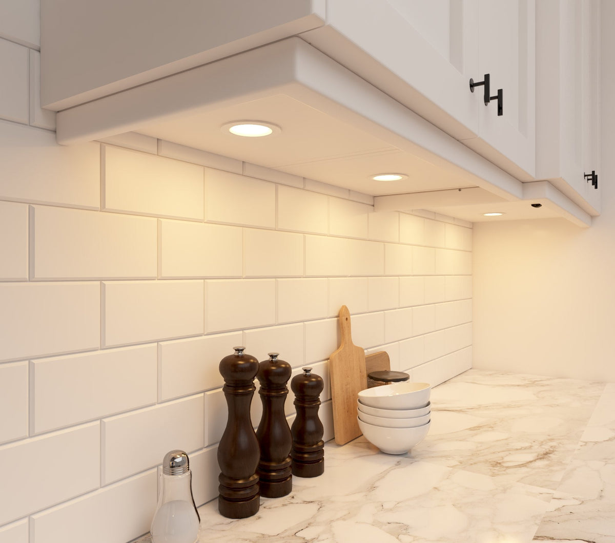 Warm white INLIGHT IN-0102 puck lights recessed under white kitchen cabinets
