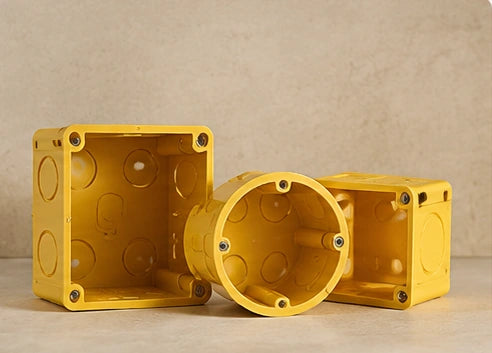 Illustrative yellow junction boxes on a warm neutral surface from the approved category design; actual product details are shown on product pages.